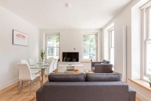 a living room with a couch and a table at Fitzrovia & Soho - 3BR - CityApartmentStay in London