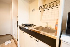 a kitchen with a sink and a refrigerator at Shinjuku Waseda Earthtone Apartment in Tokyo