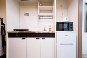 a kitchen with a sink and a microwave at Shinjuku Waseda Earthtone Apartment in Tokyo +49 photos