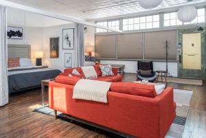 a living room with a red couch and a bed at High-design Downtown Loft in Asheville