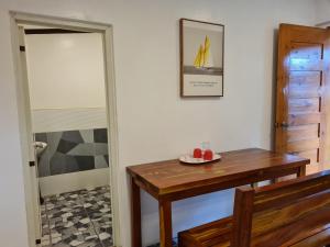 uma sala de jantar com uma mesa de madeira e uma porta em Tambayan Rooms and Cottages by SMS Hospitality em Carmen