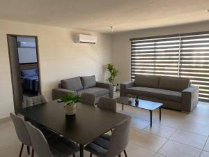 una sala de estar con una mesa y un sofá en Increíble departamento Club de Playa canchas de pádel para 8 huéspedes, en Acapulco