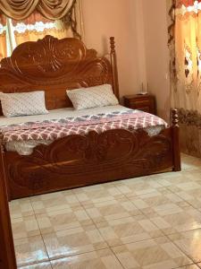 a large wooden bed in a room with at Brufut Luxury Villa in Brufut