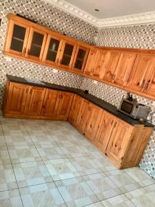 a kitchen with wooden cabinets and a tile floor at Brufut Luxury Villa in Brufut