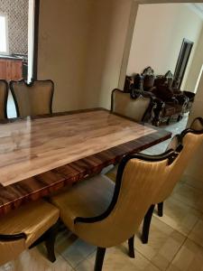 un tavolo in legno con sedie in pelle e un tavolo in legno di Brufut Luxury Villa a Brufut