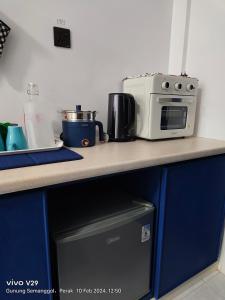 a kitchen counter with a microwave on top of it at Santorini by Loteloft at Bukit Merah Laketown in Simpang Ampat Semanggol