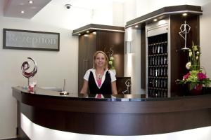 a woman sitting at a counter in a bar at Hotel Lousberg in Aachen