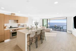 a kitchen and living room with a view of the ocean at Aquazzura - By Stay Awhile Villas in Malibu