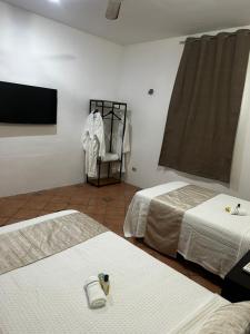 a room with two beds and a flat screen tv at house with pool yucatan in Ucú +15 photos