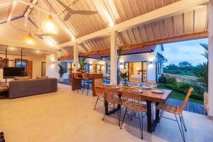 ein Esszimmer und ein Wohnzimmer mit einem Tisch und Stühlen in der Unterkunft New 3BR villa,Sunset &ricefield views Canggu area! in Kerobokan