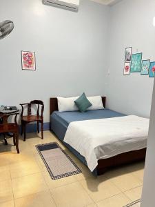 1 dormitorio con 2 camas, escritorio y mesa en MOCA MOTEL, en Cao Lãnh