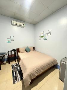 ein Schlafzimmer mit einem Bett und einem Schreibtisch in einem Zimmer in der Unterkunft MOCA MOTEL in Cao Lãnh