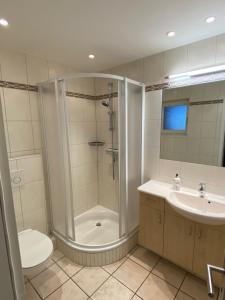 a bathroom with a shower and a toilet and a sink at Traumapartment Haus Stoertebeker - Strandnah und trotzdem zentral in Westerland +20 photos