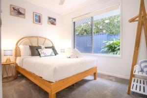 a bedroom with a large bed and a window at Pet Friendly Battery Hill Home away from Home in Caloundra