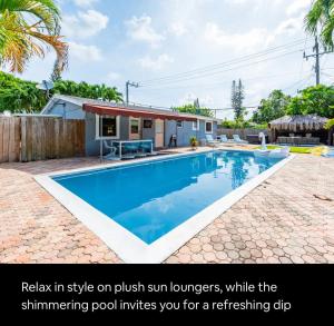 una piscina en un patio trasero con una casa en Philllips Tropical Paradise, en Fort Lauderdale