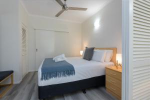 una camera con letto e comò con ventilatore a soffitto di 1 Bedroom @ Palm Villas #22 a Port Douglas