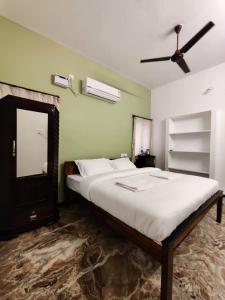 sypialnia z dużym łóżkiem i wentylatorem sufitowym w obiekcie Maison Nataraja w mieście Puducherry