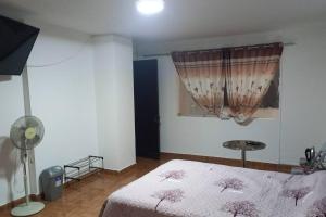 een slaapkamer met een bed, een lamp en een raam bij Apartamento Bear house Family in Lima