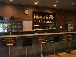 a bar with chairs and a clock on the wall at Kamikochi Hotel in Matsumoto