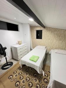 um pequeno quarto com 2 camas e uma secretária em Apartamento no Centro em Porto Seguro