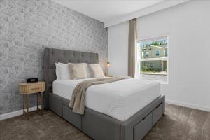 Un dormitorio con una cama grande y una ventana en 5 Bedroom- 4 Bathroom- Storey Lake 2601 Ss, en Kissimmee