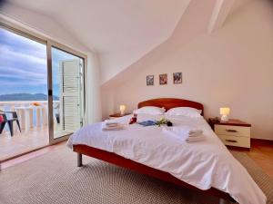 a bedroom with a large bed and a balcony at Terrace apartments in Ubli