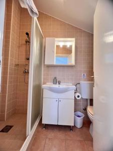 a bathroom with a sink and a toilet at Terrace studios with panoramic seaview in Ubli
