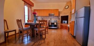 een keuken met een tafel en stoelen en een koelkast bij Speroni d'oro in San Pietro in Bevagna