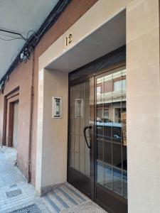 an entrance to a building with a large glass door at Gabriella Apartment Near the beach in Puerto de Sagunto