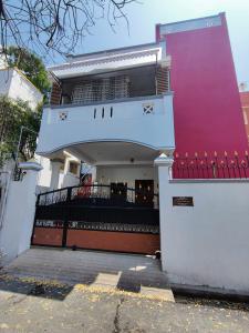 une maison blanche et rouge avec un portail dans l'établissement Maison Nataraja, à Pondichéry