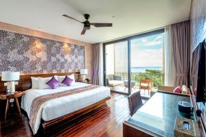 a hotel room with a bed and a balcony at Salinda Resort Phu Quoc - Sparkling Wine Breakfast in Phu Quoc