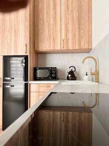 a kitchen with a black refrigerator and a microwave at Apartament Old Town Bednarska 22 in Elblag