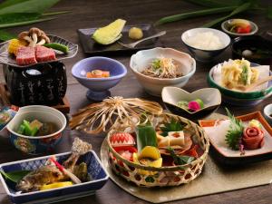 a table with many bowls of food on it at Kamikochi Hotel in Matsumoto