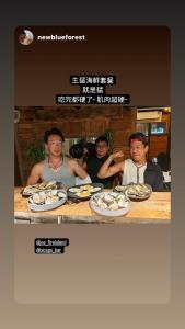 a group of people sitting at a table with plates of food at Star-Moon B&B Green Island in Green Island