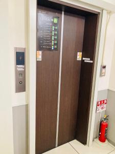 Un ascensor marrón en un edificio con un cartel. en レオラ, en Osaka