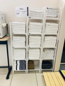 una pila de toallas blancas en un estante en レオラ, en Osaka