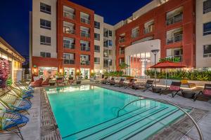 洛杉磯的住宿－Charming Luxury Apartment with Hollywood Sign View，一座带椅子的酒店游泳池,一座建筑