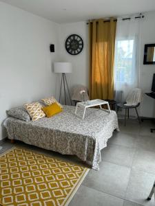 ein Schlafzimmer mit einem Bett und einer Uhr an der Wand in der Unterkunft Chambre près de Walygator et Aqualand in Brax