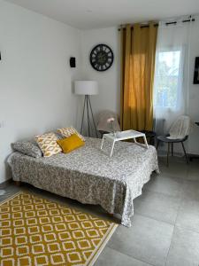 ein Schlafzimmer mit einem Bett und einer Uhr an der Wand in der Unterkunft Chambre près de Walygator et Aqualand in Brax
