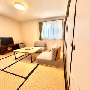una pequeña sala de estar con mesa y silla en 湖北 寺の宿- GuestHouse去-来-現Ko-Rai-Gen en Nagahama