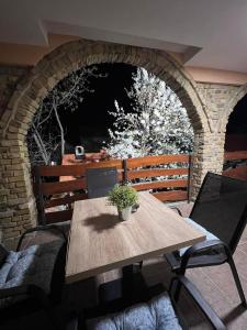 a wooden table with a potted plant on a patio at Guest House LILA in Sombor