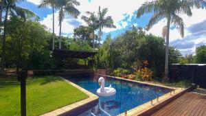 a swimming pool with a swan in a backyard at Rancho Relaxo in Tewantin