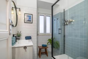 baño con lavabo y ducha con azulejos azules en Superb Apartments Overlooking Graça in Lisbon, en Lisboa