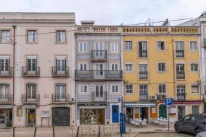 une rangée de bâtiments dans une rue de la ville dans l'établissement Superb Apartments Overlooking Graça in Lisbon, à Lisbonne