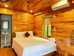 a bedroom with a bed in a wooden room at Cao Thạch Homestay in Ninh Binh