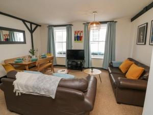 a living room with a couch and a table at Harbour Cottage in Ilfracombe