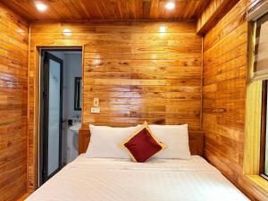 a bedroom with a bed in a wooden wall at Cao Thạch Homestay in Ninh Binh