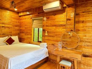 a bedroom with wooden walls and a bed and a table at Cao Thạch Homestay in Ninh Binh +25 photos