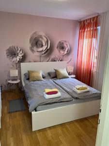 1 dormitorio con 1 cama con flores en la pared en Fly Inn, en Velika Gorica