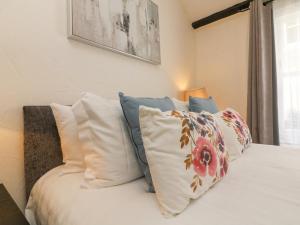 Un dormitorio con una cama con almohadas. en Harbour Cottage, en Ilfracombe